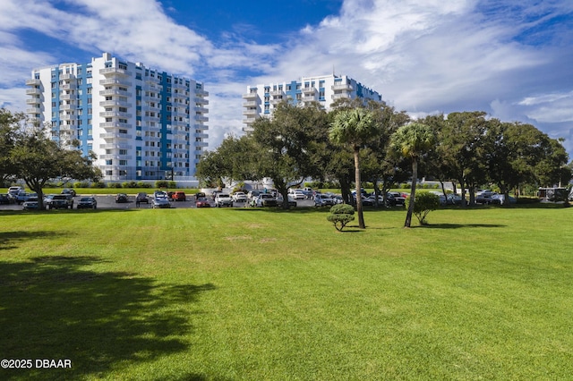 surrounding community featuring a lawn and uncovered parking