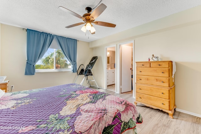 bedroom featuring ceiling fan, baseboards, light wood finished floors, and a textured ceiling