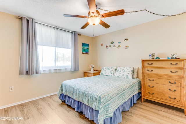 bedroom featuring a ceiling fan, baseboards, light wood finished floors, and a textured ceiling