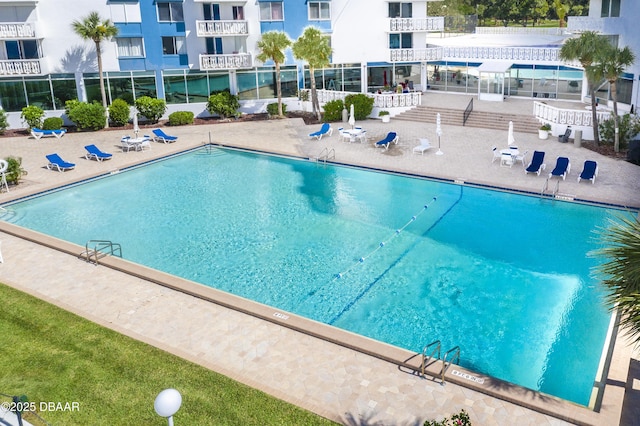 pool with a patio and fence