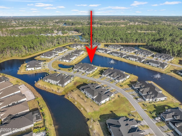 drone / aerial view featuring a residential view, a water view, and a forest view