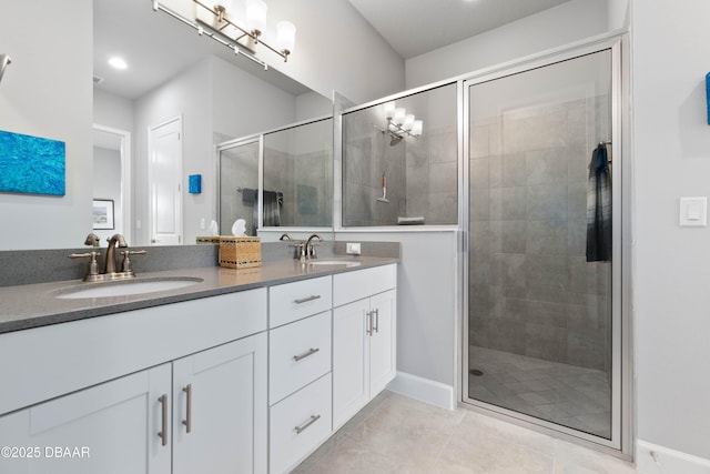 bathroom featuring a shower with door and vanity