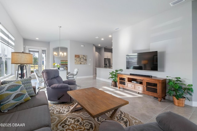 living room with an inviting chandelier, baseboards, light tile patterned floors, and visible vents