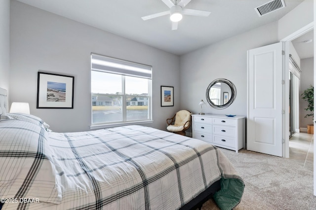 bedroom featuring a ceiling fan, light colored carpet, and visible vents