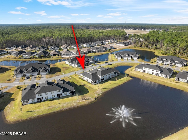 aerial view featuring a water view, a wooded view, and a residential view