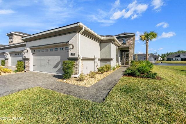 view of home's exterior with decorative driveway, a yard, stucco siding, a garage, and stone siding