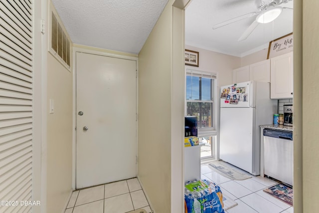 721 S Beach St Unit 205, Daytona Beach, FL 32114 - kitchen featuring freestanding refrigerator, stainless steel dishwasher, a ceiling fan, light tile patterned floors, and white cabinets