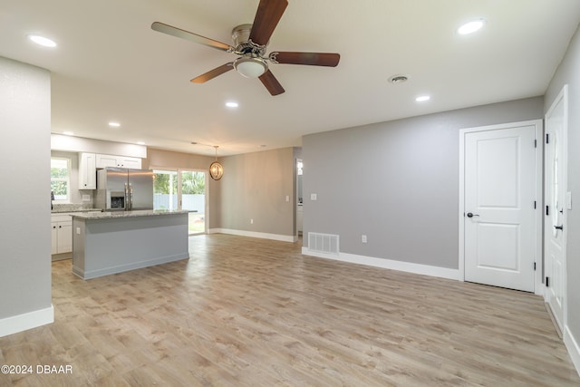 unfurnished living room with light hardwood / wood-style floors and ceiling fan