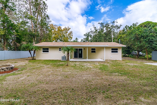 rear view of house featuring central AC, a lawn, and a patio