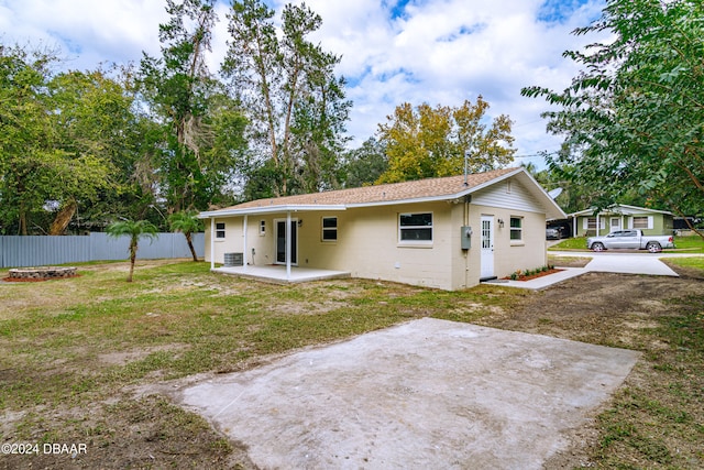 back of property featuring a patio area and a yard