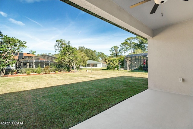 view of yard featuring ceiling fan and a lanai