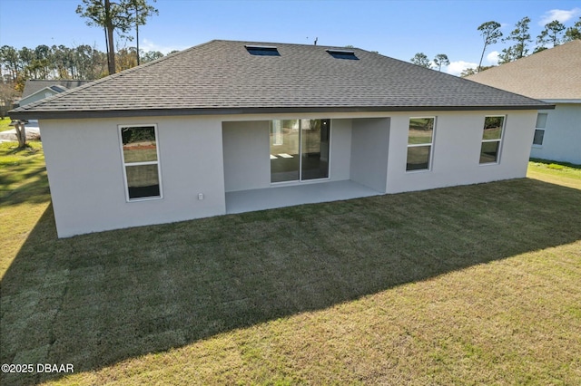 back of property with a yard and a patio area