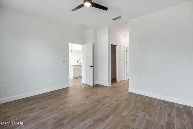 unfurnished bedroom with a closet, ceiling fan, and sink