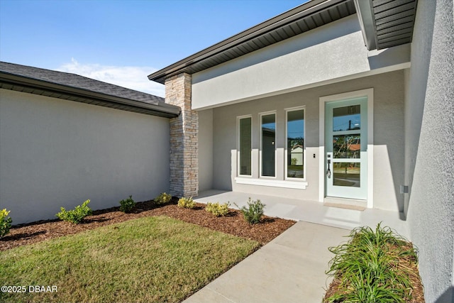 view of exterior entry with a lawn