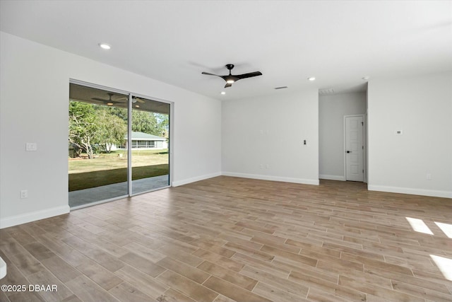 empty room with ceiling fan and light hardwood / wood-style flooring