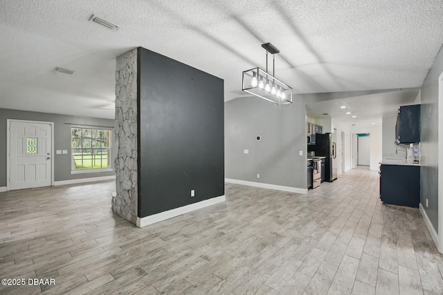 2950 Ragis Rd, Edgewater, FL 32132 - unfurnished living room featuring light wood-style floors and a textured ceiling