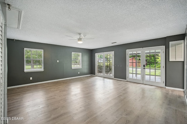 2950 Ragis Rd, Edgewater, FL 32132 - spare room featuring a ceiling fan, wood finished floors, healthy amount of natural light, and a textured ceiling