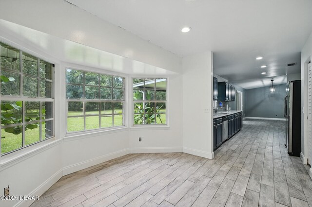 2950 Ragis Rd, Edgewater, FL 32132 - kitchen with freestanding refrigerator, light countertops, light wood finished floors, dark cabinets, and recessed lighting