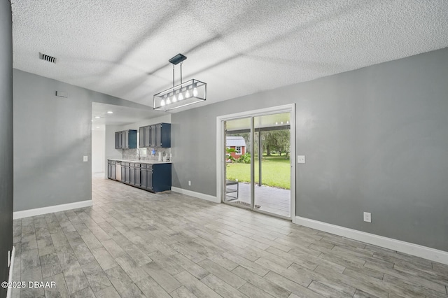 2950 Ragis Rd, Edgewater, FL 32132 - unfurnished living room with a textured ceiling, light wood-style flooring, and lofted ceiling