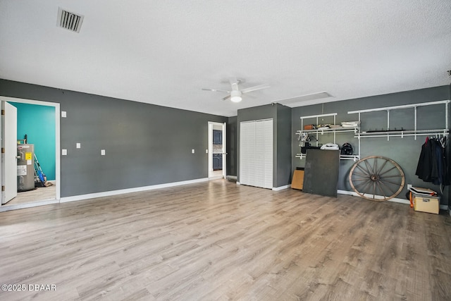 2950 Ragis Rd, Edgewater, FL 32132 - unfurnished living room featuring attic access, electric water heater, wood finished floors, and a ceiling fan