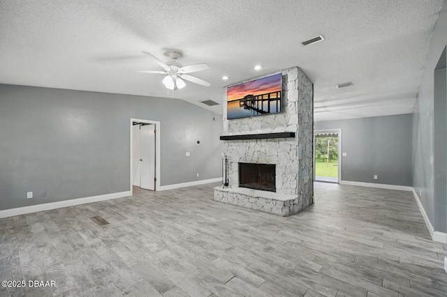 2950 Ragis Rd, Edgewater, FL 32132 - unfurnished living room with a textured ceiling, a stone fireplace, a ceiling fan, wood finished floors, and lofted ceiling