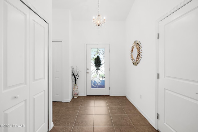665 Elk River Dr, Ormond Beach, FL 32174 - entryway featuring dark tile patterned floors and an inviting chandelier
