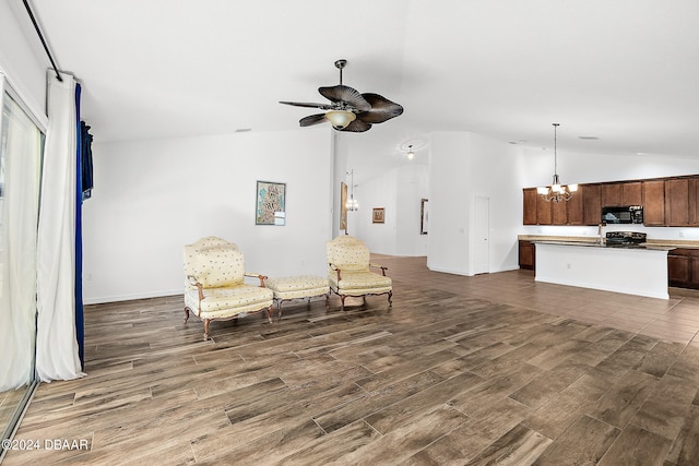 665 Elk River Dr, Ormond Beach, FL 32174 - sitting room with ceiling fan with notable chandelier, dark wood-type flooring, and vaulted ceiling