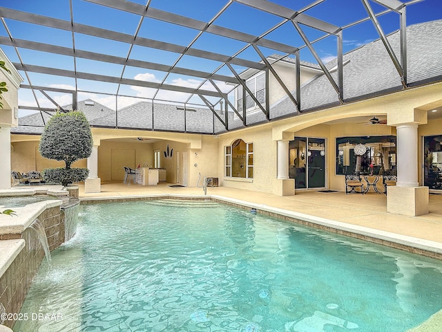 view of swimming pool with pool water feature, a patio area, ceiling fan, and glass enclosure