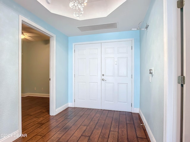 unfurnished bedroom with a closet, a chandelier, and dark hardwood / wood-style floors