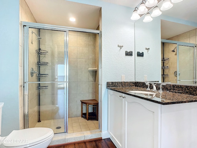 bathroom featuring vanity, wood-type flooring, and a shower with shower door