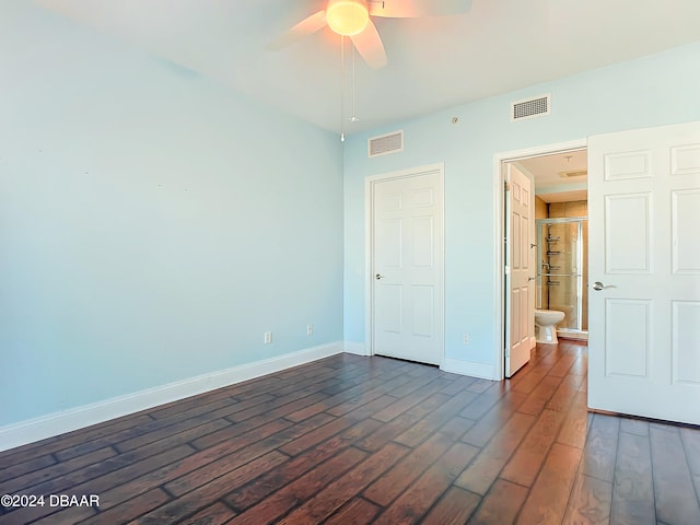 unfurnished bedroom with ceiling fan and dark wood-type flooring