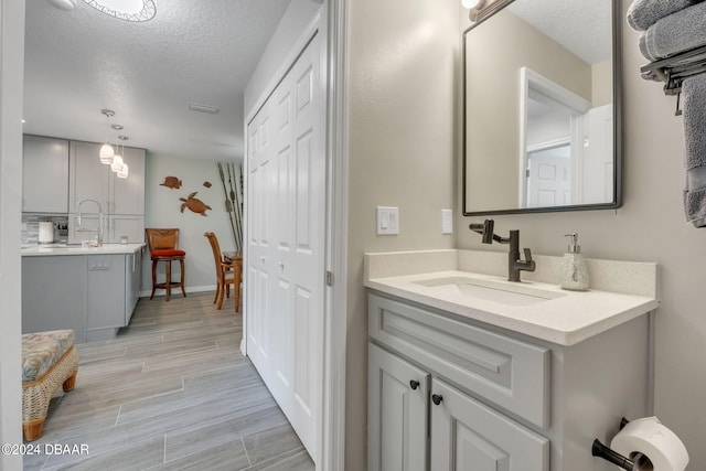 bathroom with vanity, a textured ceiling, and hardwood / wood-style flooring