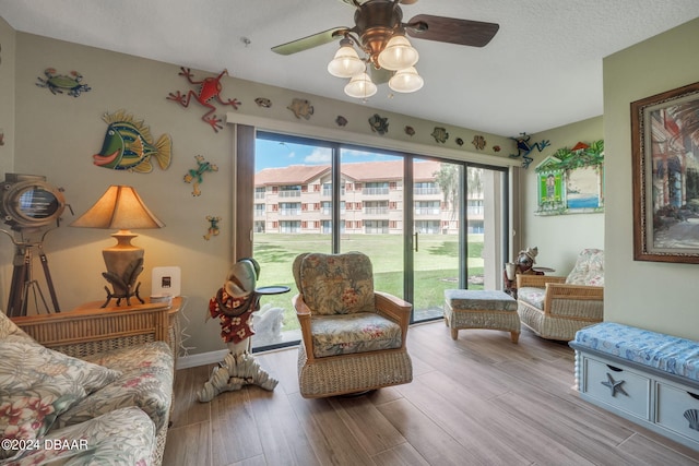 sitting room featuring ceiling fan, a textured ceiling, and light hardwood / wood-style floors