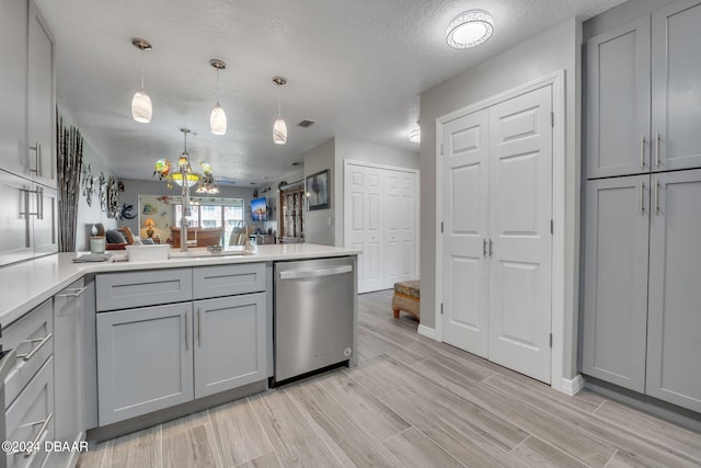 kitchen featuring light hardwood / wood-style floors, a textured ceiling, hanging light fixtures, gray cabinets, and dishwasher