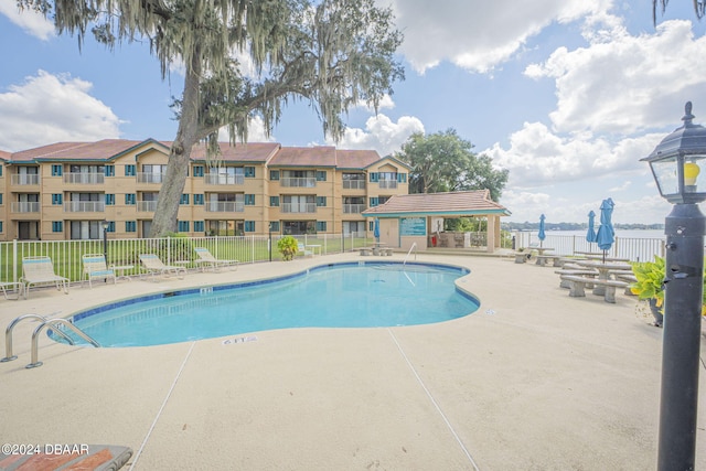 view of pool featuring a water view, a patio, and a gazebo