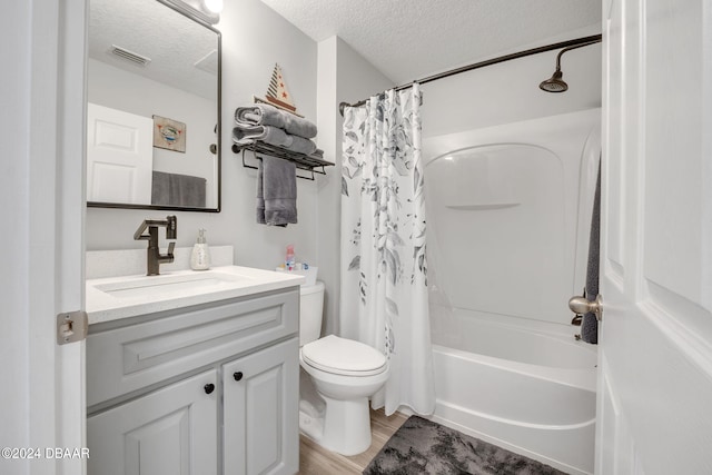 full bathroom with a textured ceiling, shower / bathtub combination with curtain, wood-type flooring, vanity, and toilet