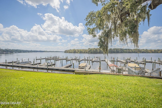 view of dock with a water view and a yard