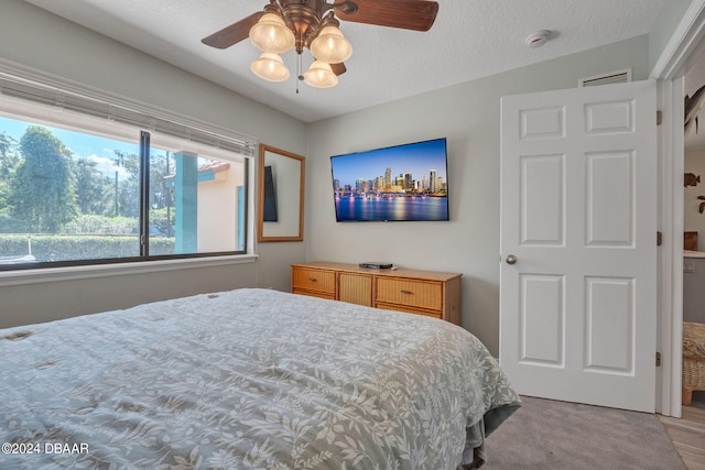 bedroom with ceiling fan and a textured ceiling