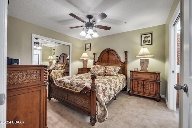 carpeted bedroom with ceiling fan, a textured ceiling, and a closet