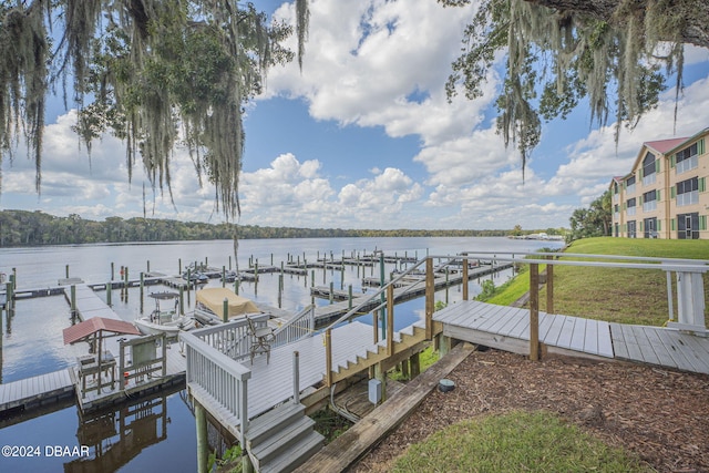 view of dock featuring a water view and a yard