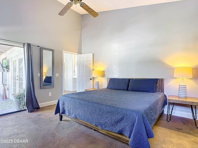 bedroom featuring ceiling fan, access to exterior, concrete flooring, and a high ceiling