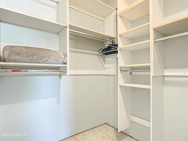 spacious closet with light tile patterned floors