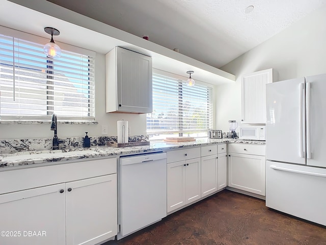 kitchen featuring sink, white appliances, white cabinetry, light stone countertops, and decorative light fixtures