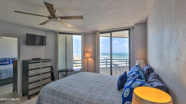 bedroom featuring light hardwood / wood-style floors, floor to ceiling windows, a textured ceiling, and ceiling fan