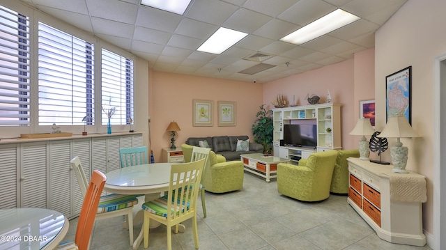 tiled living room featuring a drop ceiling