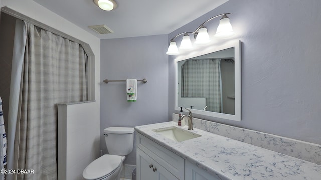 bathroom with curtained shower, vanity, and toilet