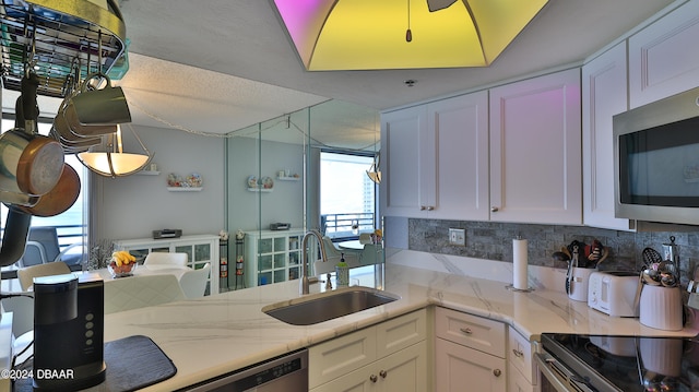 kitchen featuring white cabinets, a wealth of natural light, and appliances with stainless steel finishes