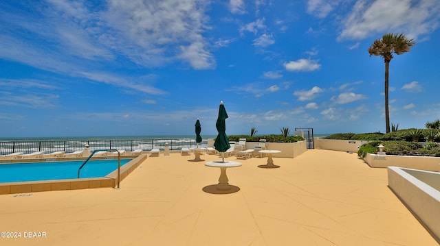 view of swimming pool with a water view and a patio area