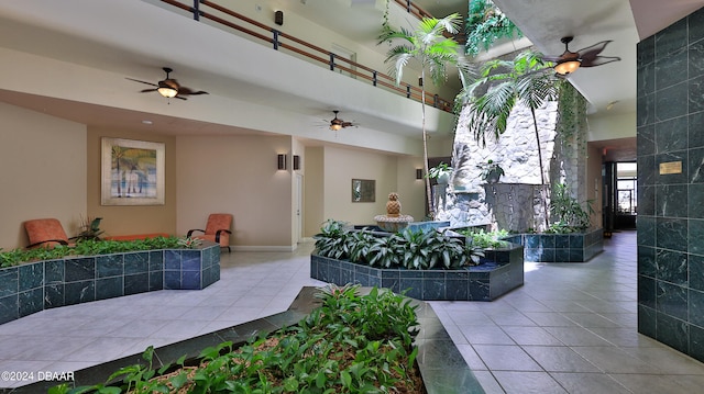 tiled living room with a high ceiling and ceiling fan