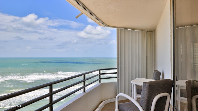 balcony featuring a beach view and a water view